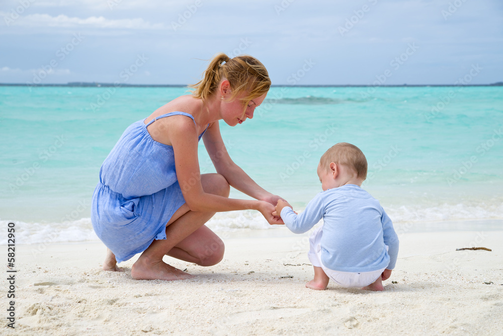 Mother is playing with baby on a beach Mother is playing with baby on a beach