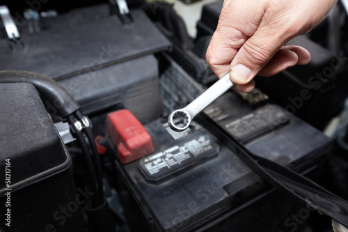 Hands of auto mechanic with wrench.