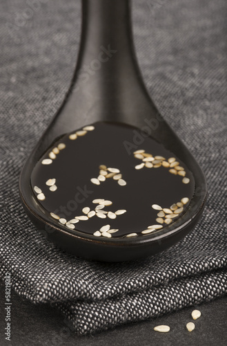 Ceramic spoon with soy sauce, close-up with selected DOF