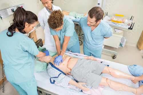 Nurses Performing CPR On Dummy Patient