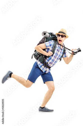 Fotografie Scared hiker with backpack and camera running away