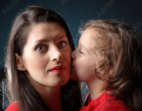 Daughter kisses her mother in her cheek