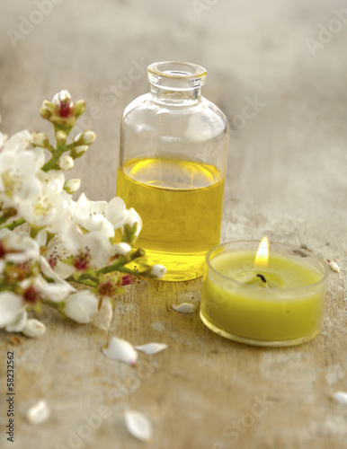 spring flower and candle with massage oil on old wooden