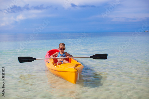Little adorable girl kayaking in the clear blue ocean © travnikovstudio
