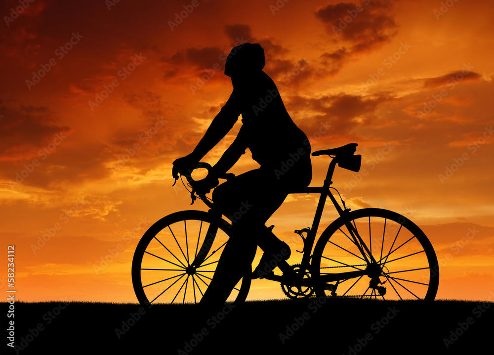 silhouette of the cyclist on road bike at sunset silhouette of the cyclist on road bike at sunset