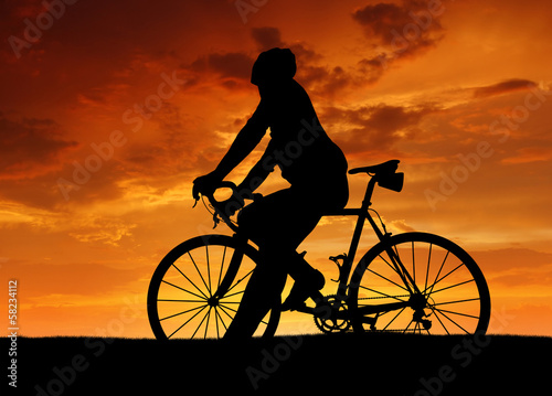 Fototapeta Naklejka Na Ścianę i Meble -  silhouette of the cyclist on road bike at sunset