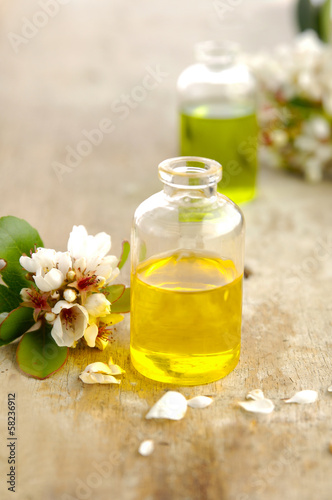 Two massage oil with spring flower on old wood
