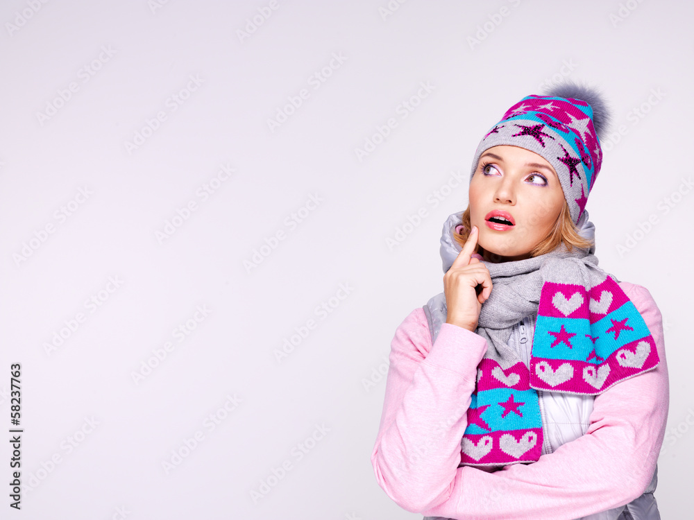 Photo of a thinking girl in winter clothes looking up Photo of a thinking girl in winter clothes looking up