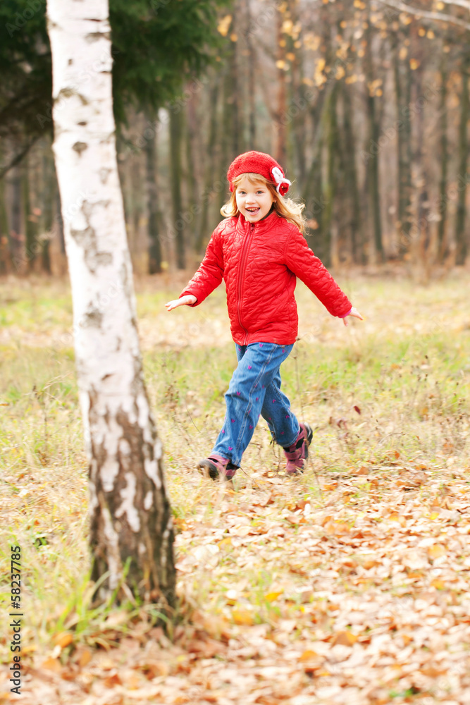 Happy smiling little girl running in forest Happy smiling little girl running in forest