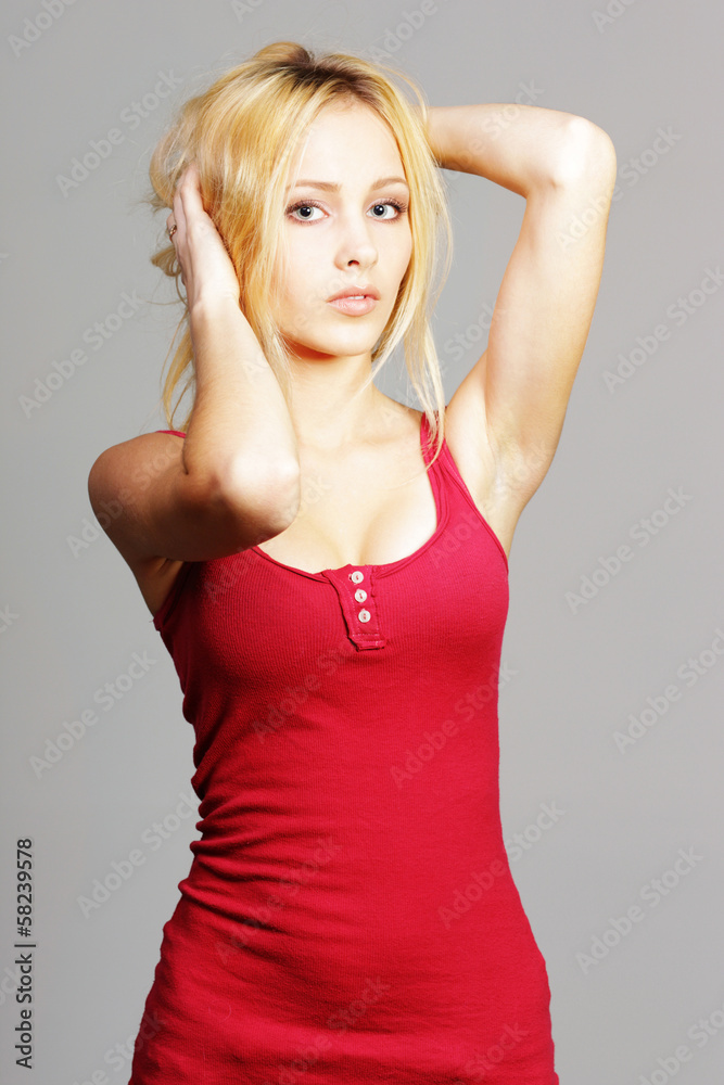 Sexy young blonde girl in red tshirt on gray background Sexy young blonde girl in red tshirt on gray background