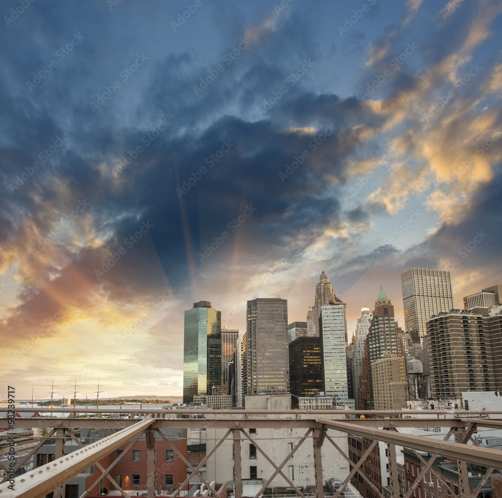 Buildings of lower Manhattan as seen from Brooklyn Bridge at sun