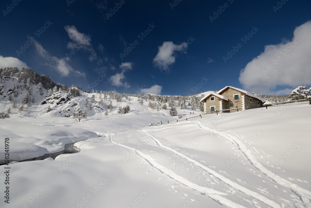 Alpine hut in winter scenic landscape