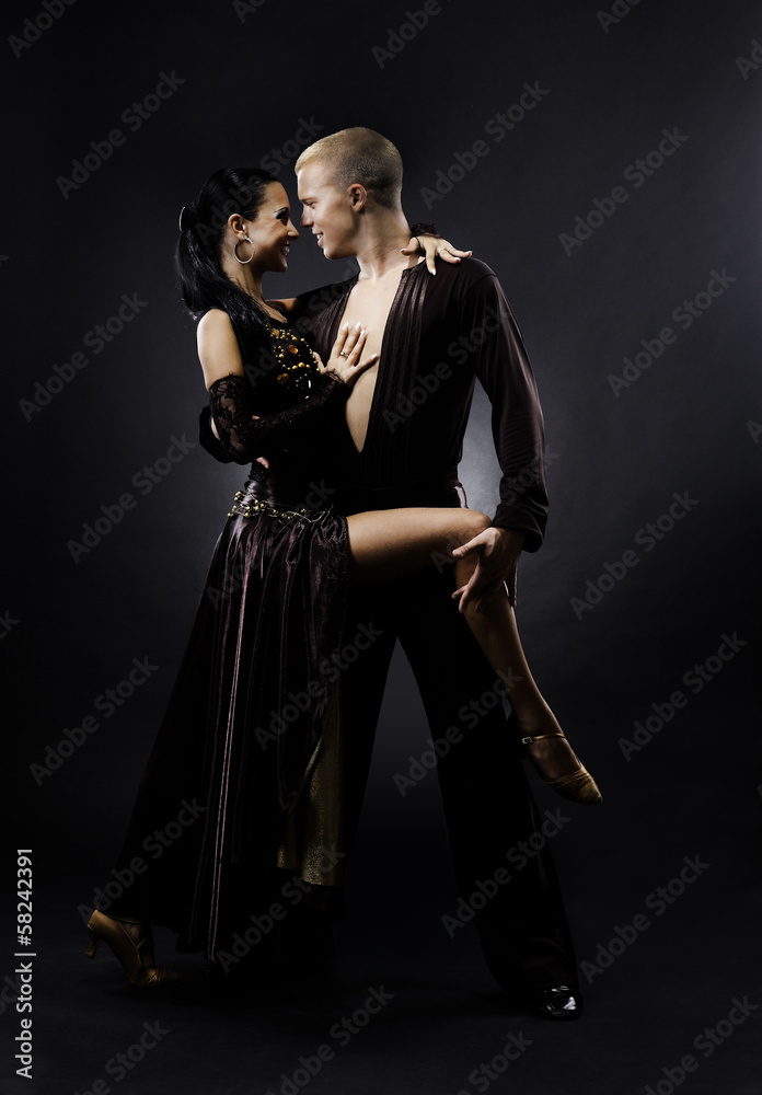 Dancing young couple on a black background.