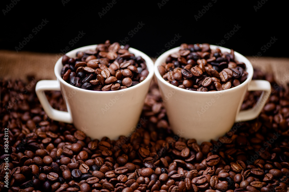 Fototapeta premium Fresh hot columbian coffee in two cups, around coffee beans