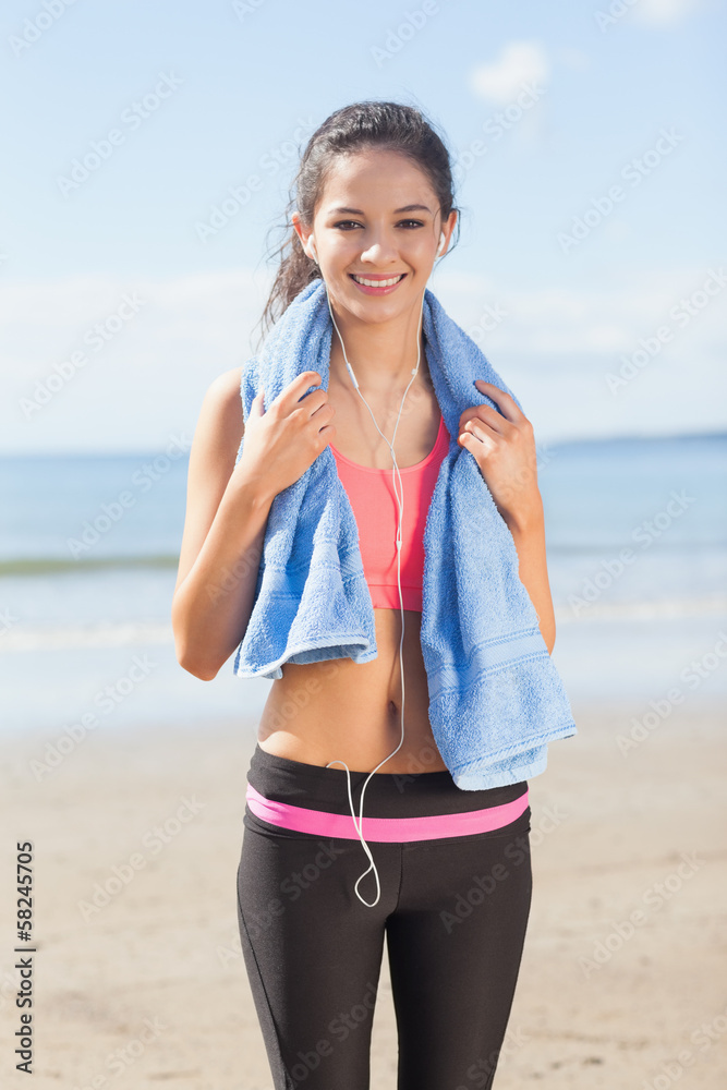 Beautiful healthy woman with towel around neck on beach Beautiful healthy woman with towel around neck on beach