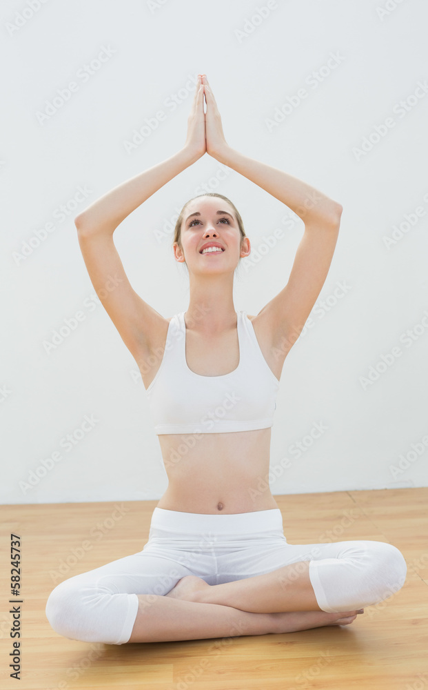 Content sporty woman meditating while sitting in lotus position
