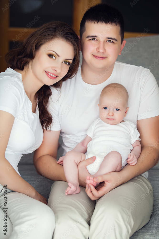 mother and father playing with their cute baby on at home