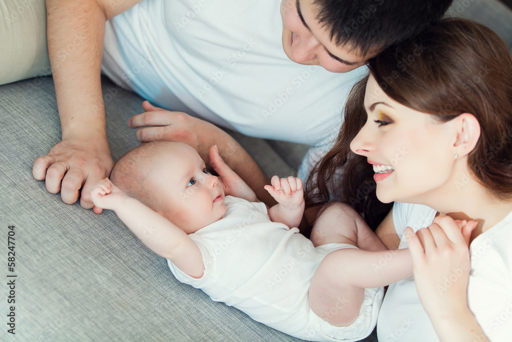 mother and father playing with their cute baby on at home mother and father playing with their cute baby on at home