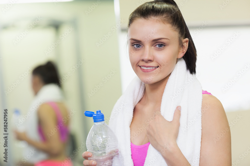 Portrait of a smiling woman with water bottle in gym Portrait of a smiling woman with water bottle in gym