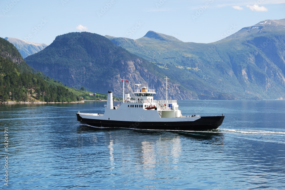 Ferry on blue water of Norwegian fjord.