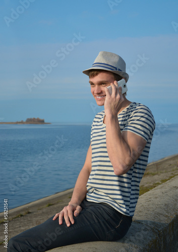 Young man speaking on a cell phone and smiling