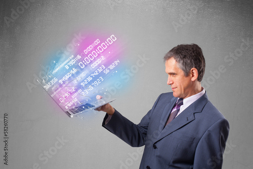 Businessman holding notebook with exploding data and numbers