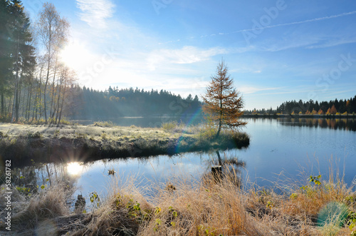 See im Herbst mit Nebel und Sonne