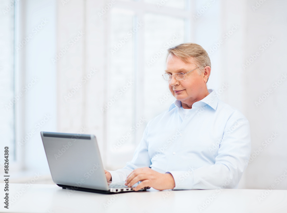 old man in eyeglasses working with laptop at home old man in eyeglasses working with laptop at home
