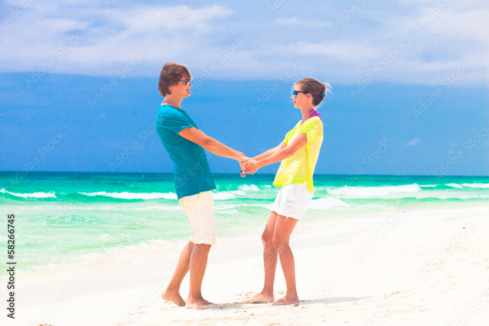 Couple walking and having fun on a tropical beach at Maldives