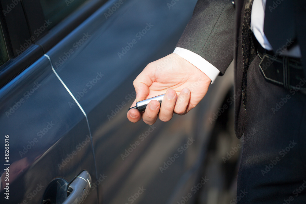 Male hand presses on the remote control car alarm systems