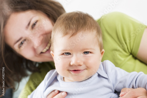 Sweet smiling baby boy laughing together with his mother.