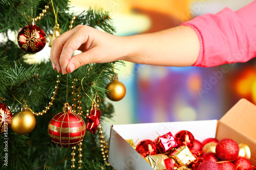 Decorating Christmas tree on bright background