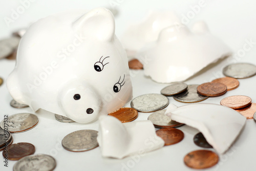 Broken Small Piggy Bank Surrounded by Spilled Coins