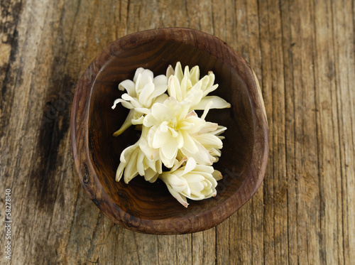 tropical flower in bowl on old wood background