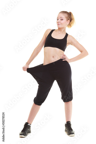 happy woman showing how much weight she lost, big pants