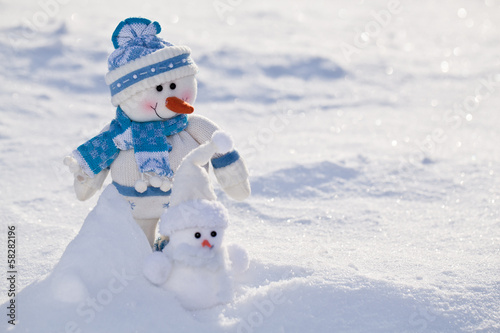Two little snowmen with carrot nose in the snow. © volff
