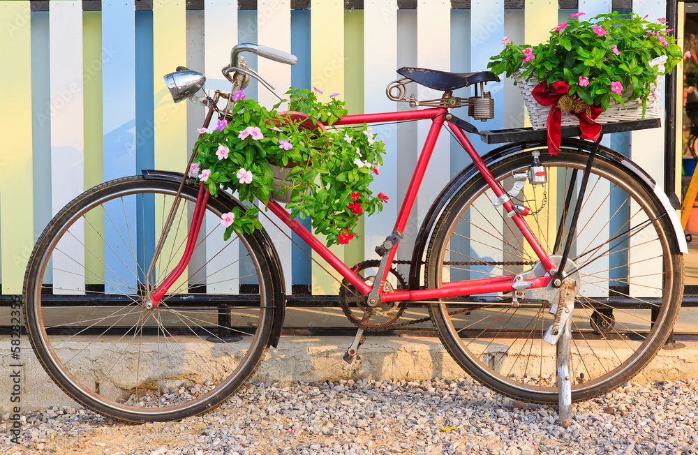 old bicycle equipped with baskets of flowers