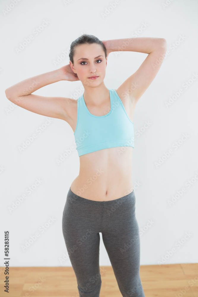 Serious fit woman standing in fitness studio Serious fit woman standing in fitness studio