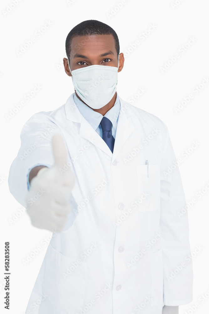 Portrait of male doctor in mask gesturing thumbs up Portrait of male doctor in mask gesturing thumbs up