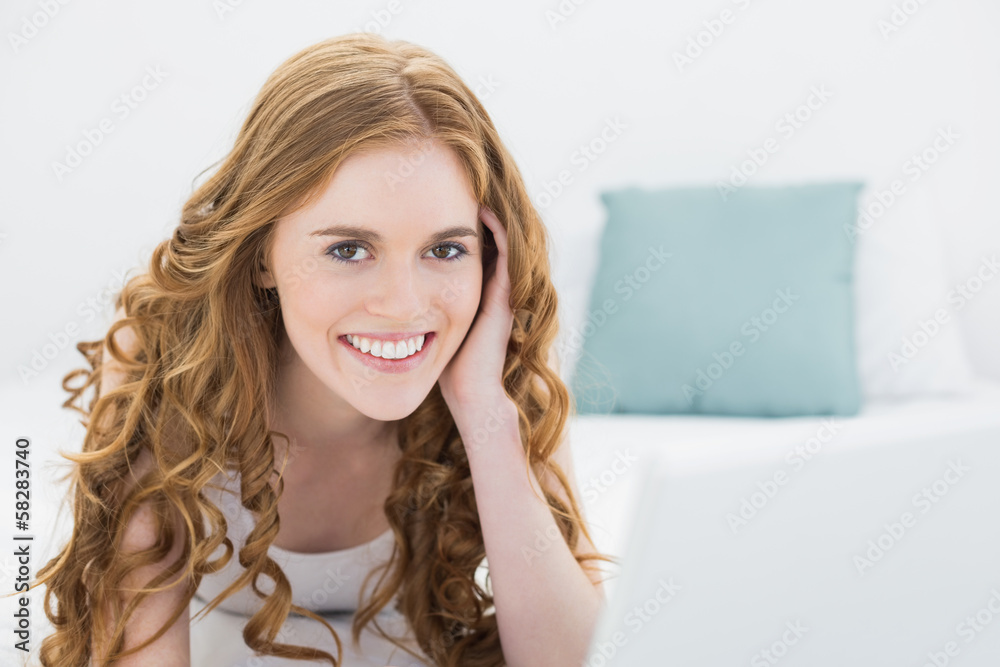 Fototapeta premium Smiling casual blond with laptop in bed