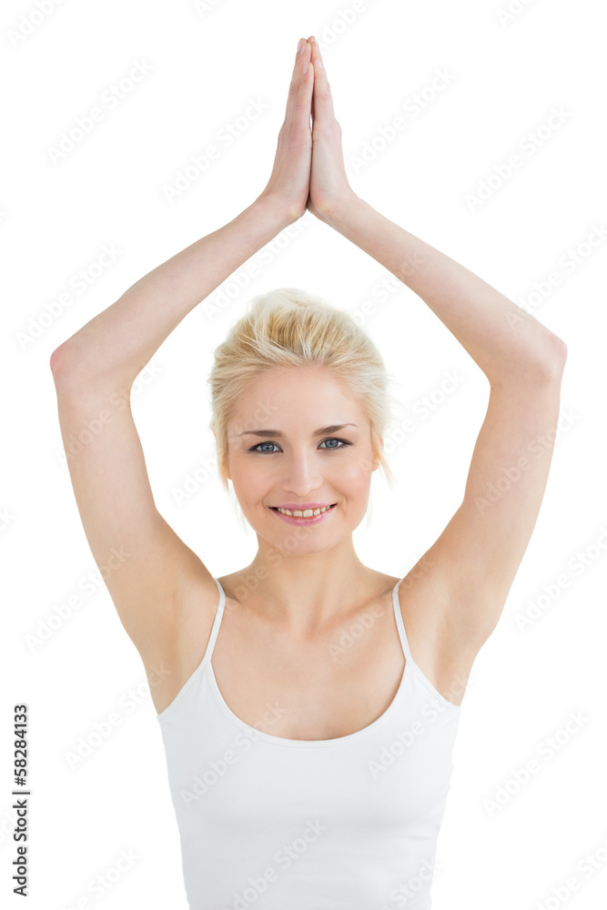 Toned young woman with joined hands over head Toned young woman with joined hands over head