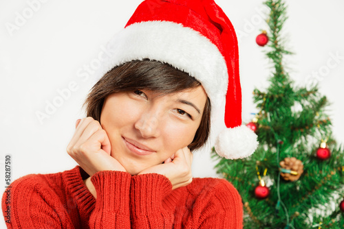 Beautiful woman in a santa hat smiles
