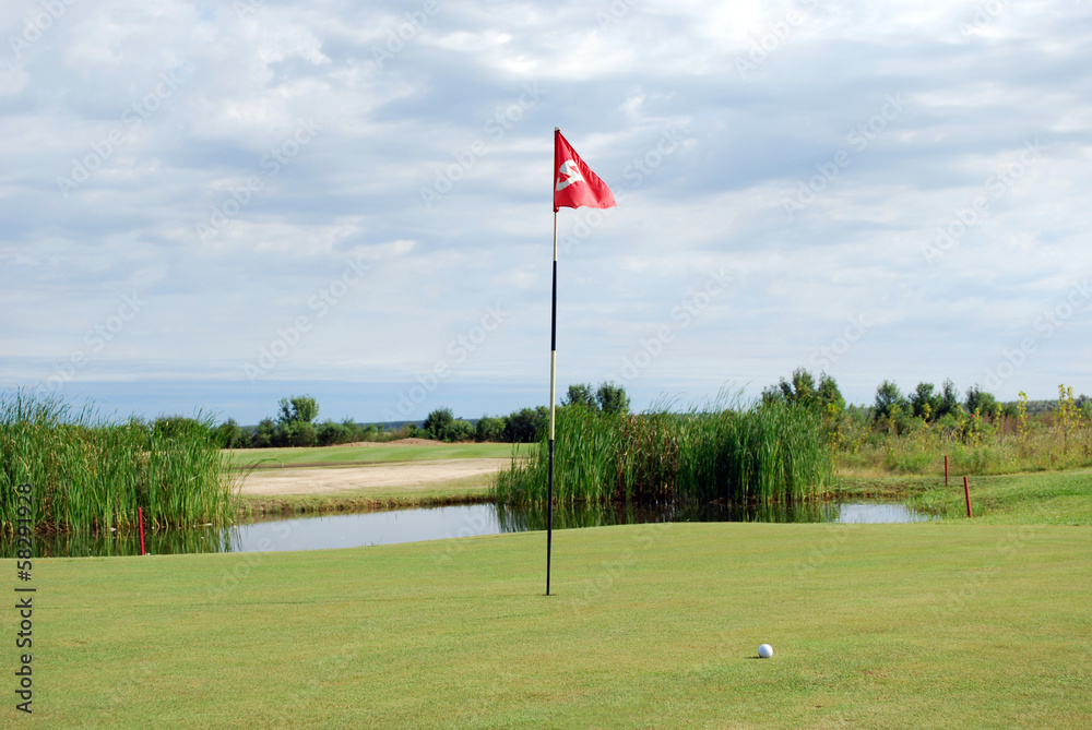 Obraz premium golf course with red flag and ball