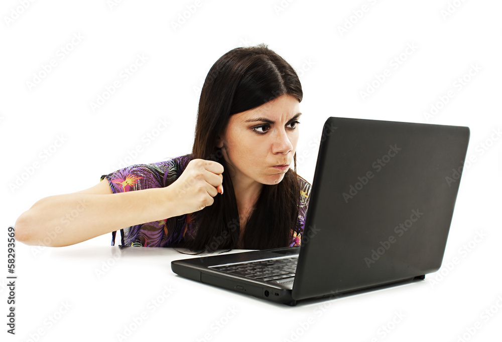 The young woman threatens with a fist to the laptop The young woman threatens with a fist to the laptop