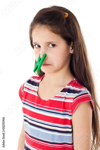 Displeased girl with clothespins on his nose