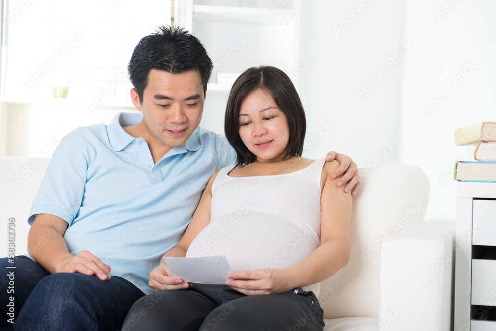 Fototapeta premium chinese pregnant mother and her husband looking at ultrascan pho