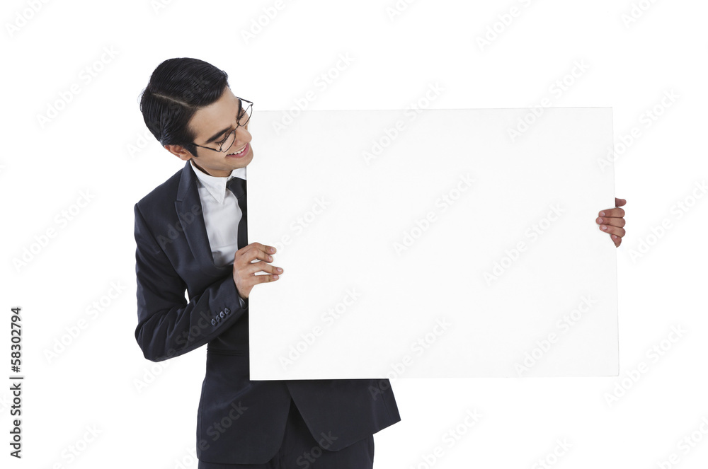 Businessman showing a blank placard and smiling Businessman showing a blank placard and smiling