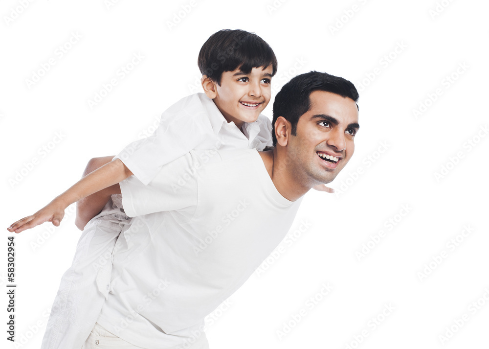 Happy boy riding piggyback on his father Happy boy riding piggyback on his father
