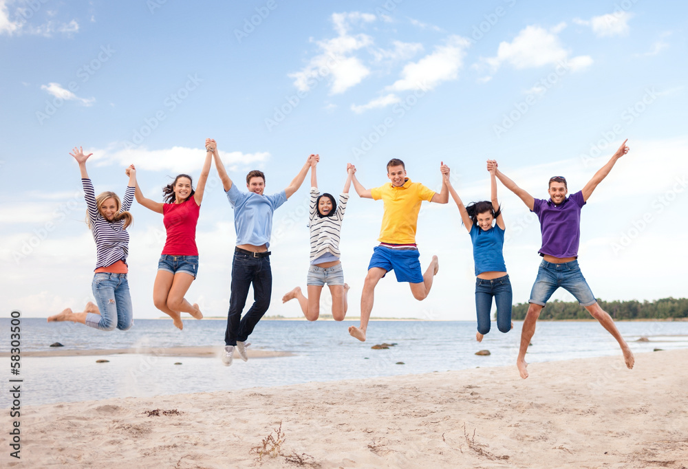Obraz premium group of friends jumping on the beach