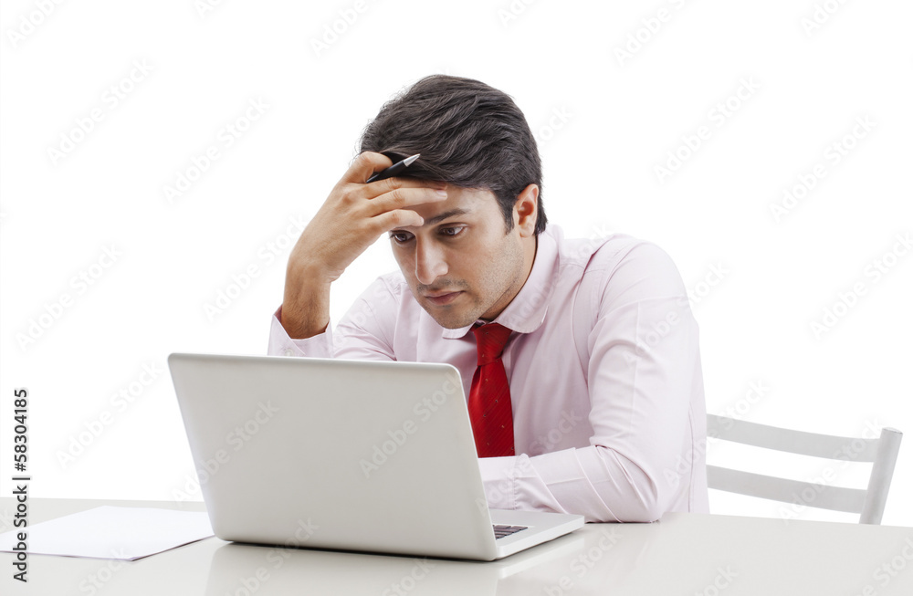 Businessman looking sad while working on a laptop Businessman looking sad while working on a laptop